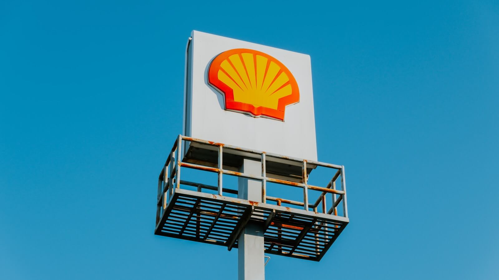 white and yellow Shell wooden signage